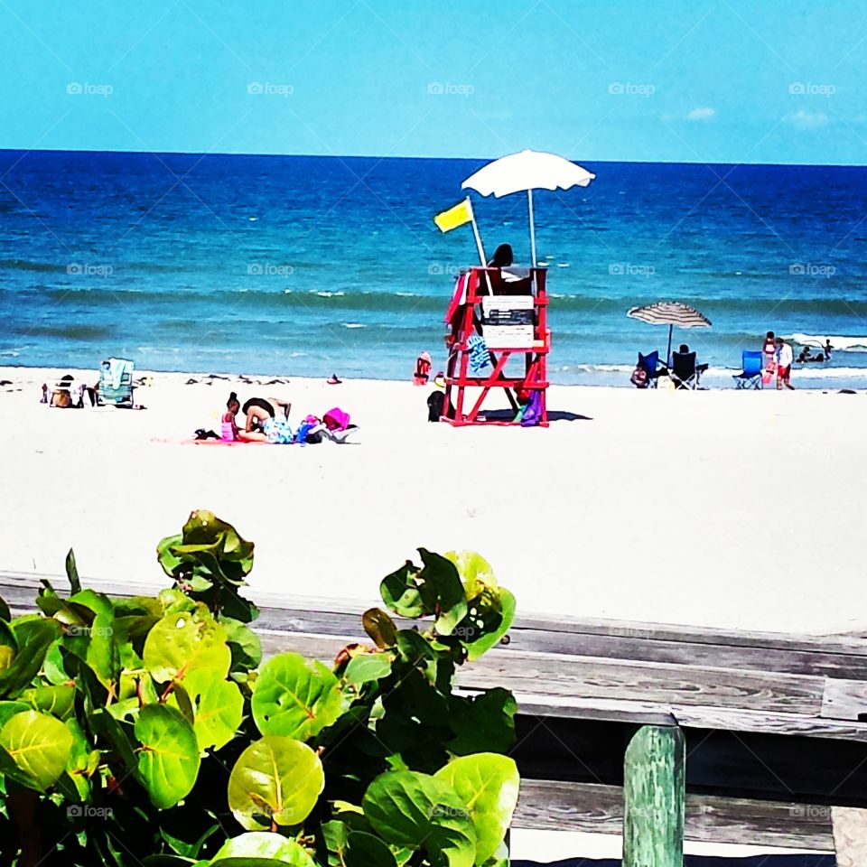 Beach at Indiatlantic, FL. I couldn't resist capturing the bright colors of the ocean, lifeguard Stand and umbrellas.