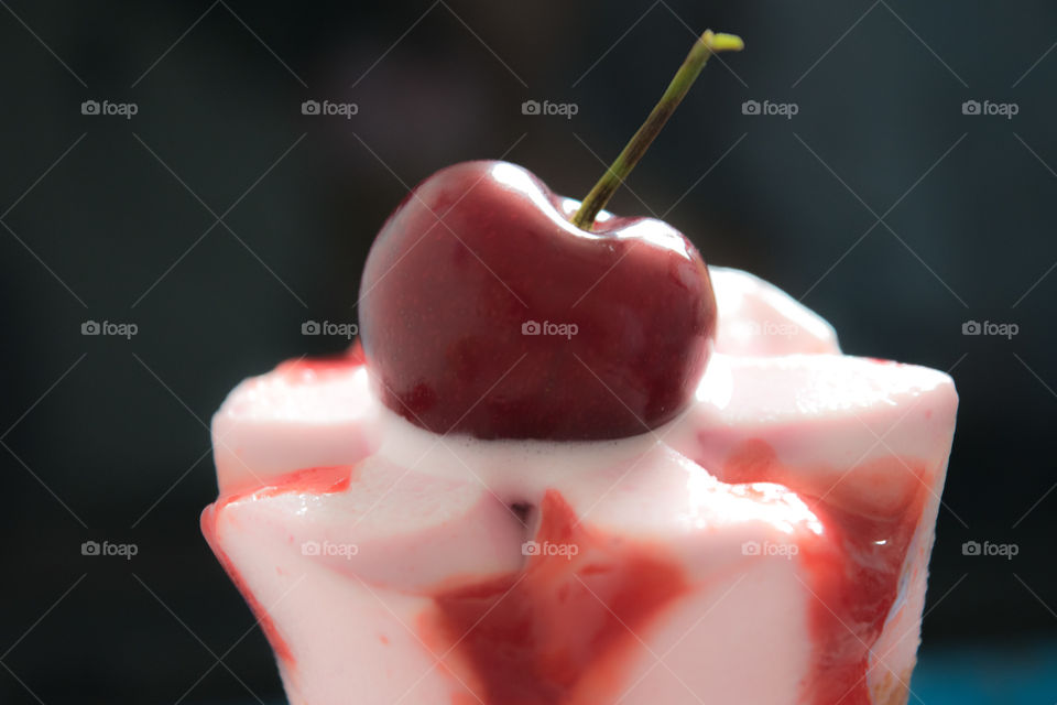 Close-up of ice cream cone with cherry