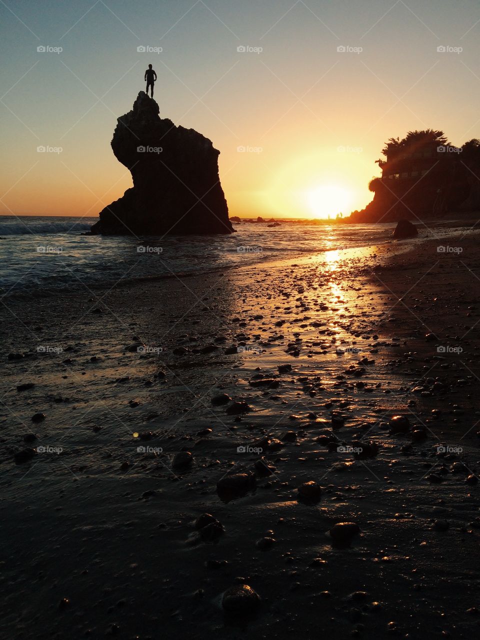 Person on a rock at sunset. 