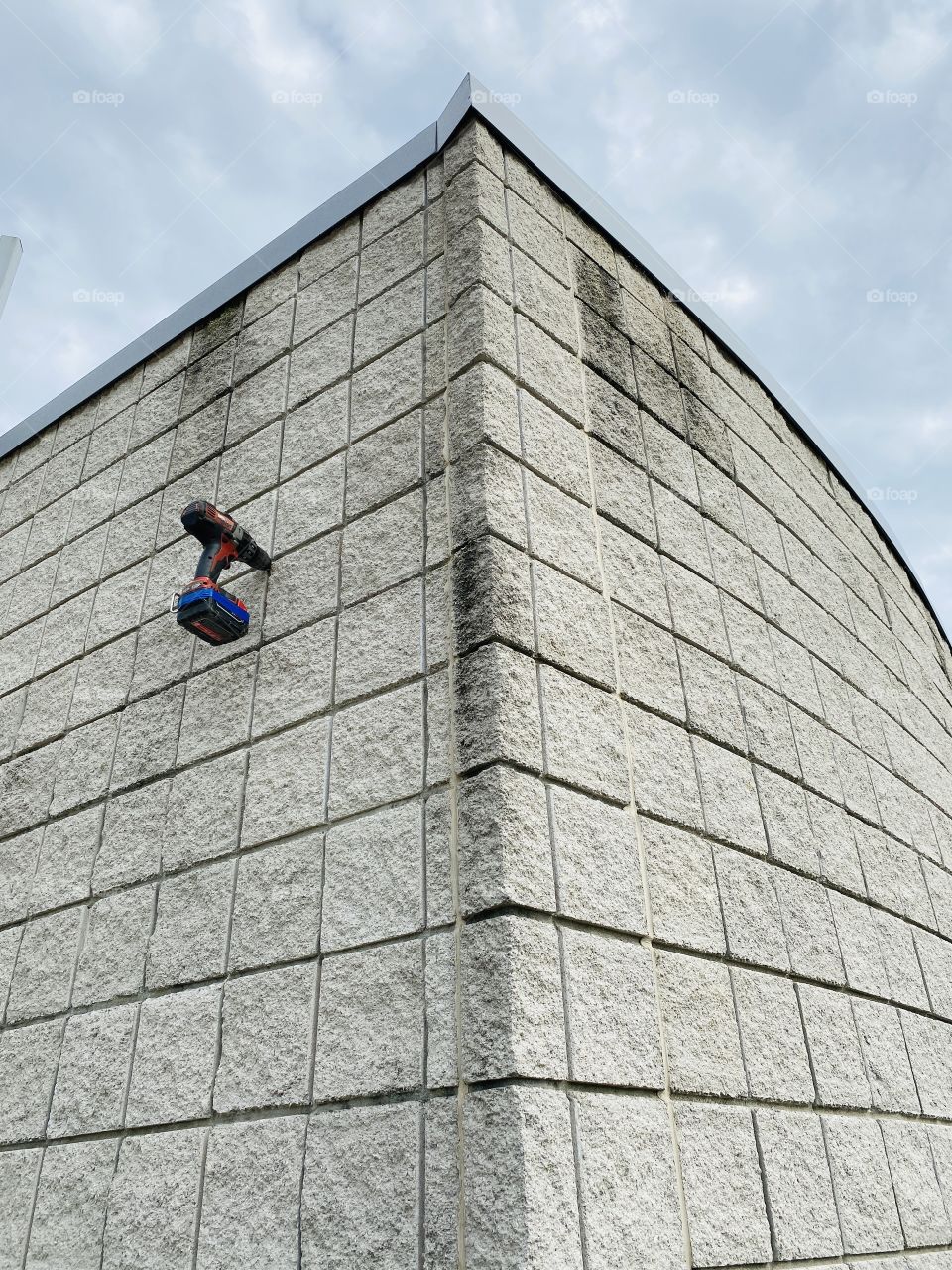 A drill left hanging from a concrete building