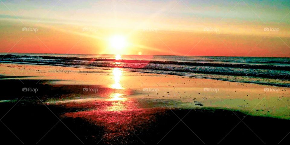 sunrises sunsets atlantic ocean sunrise reflecting on sandy beach