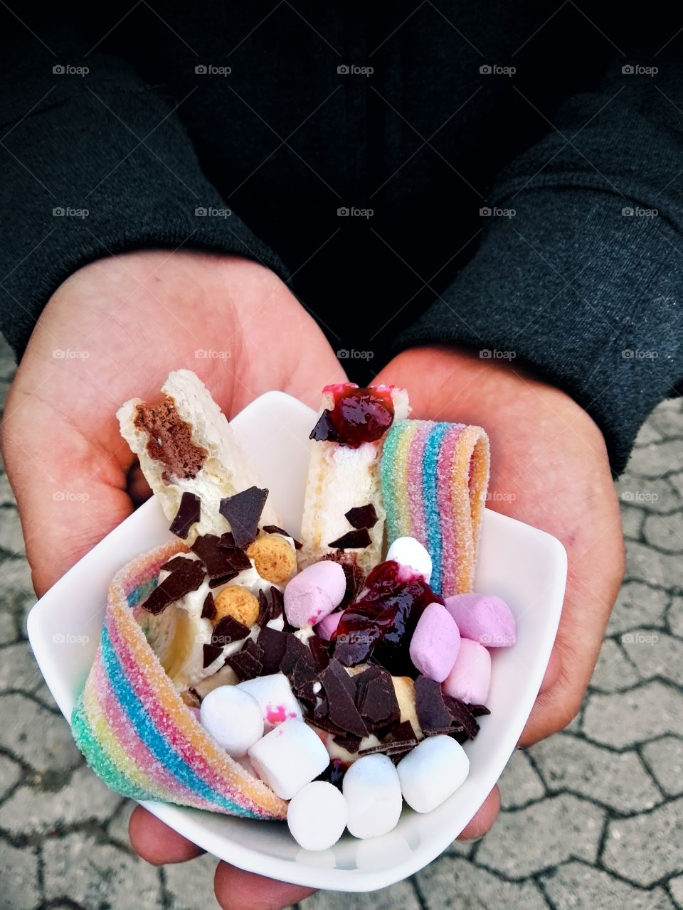 Person holding rainbow color ice cream