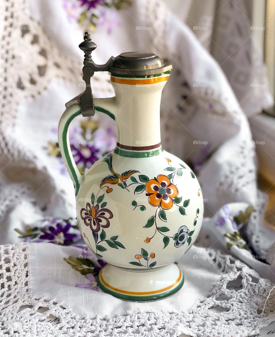 Old porcelain wine bottle with metal lid and flower pattern 