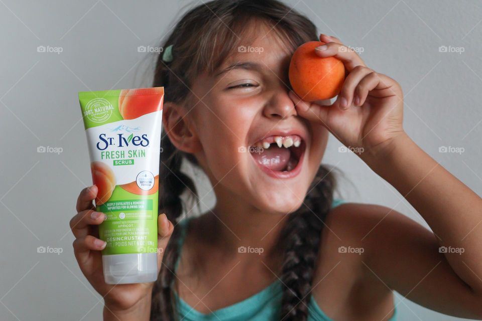 Happy smiling cute girl with St.Ives care product