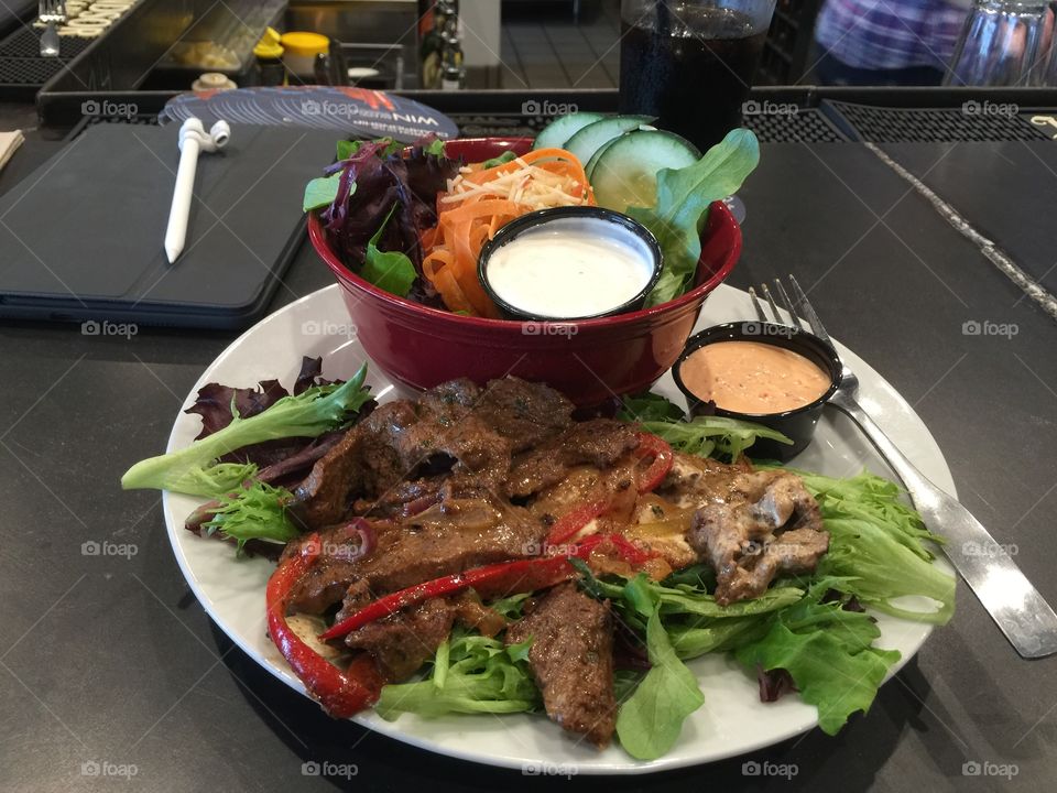 Beautifully played meal of a salad and steak 