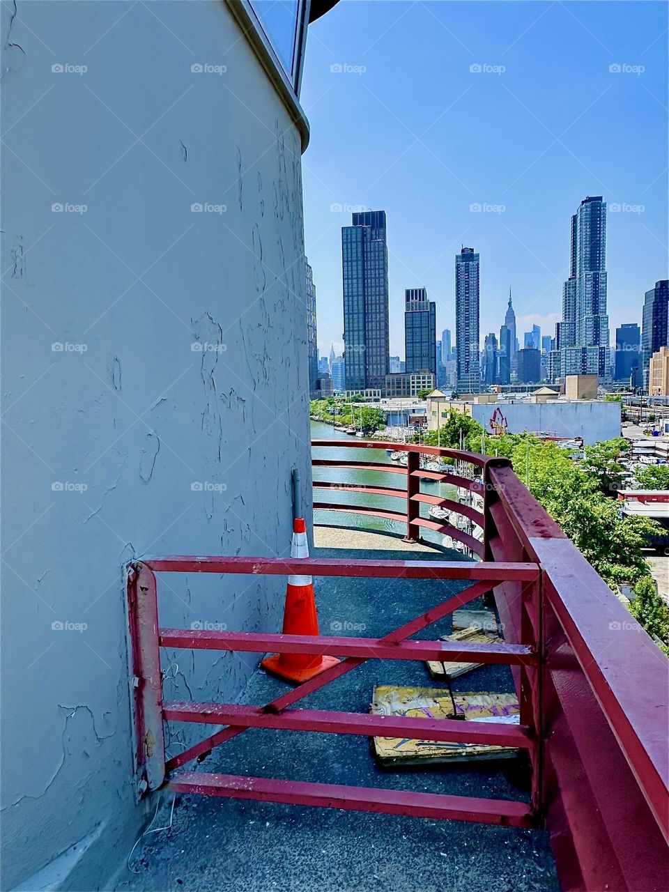 This is the central outpost of the “Pulaski Bridge” at “Newtown Creek” that connects LIC, Queens to “Greenpoint”, Brooklyn. “Manhattan” including the “Empire State Building” is visible in the distance. 2024. Hypnotic Productions