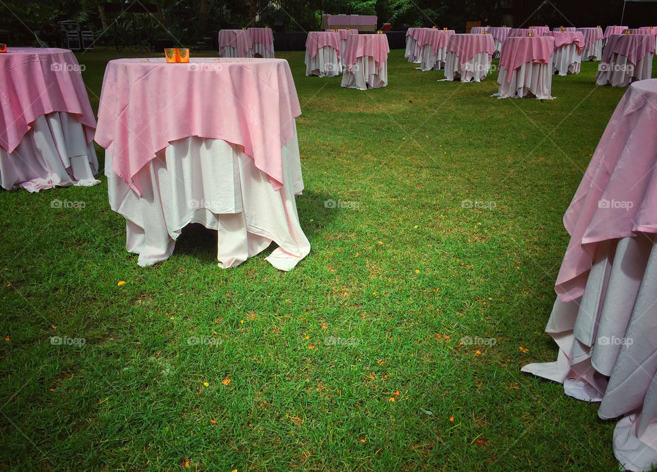 Tables being set up on a lawn in preparation for a wedding reception 