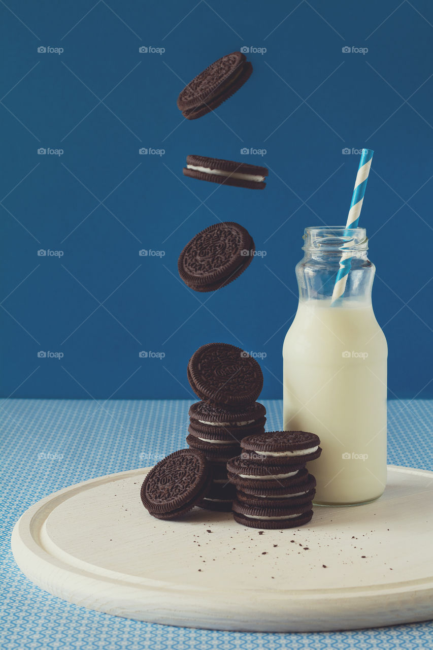 Oreo cookies and milk on blue background
