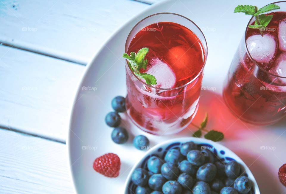 Berries with iced tea on table
