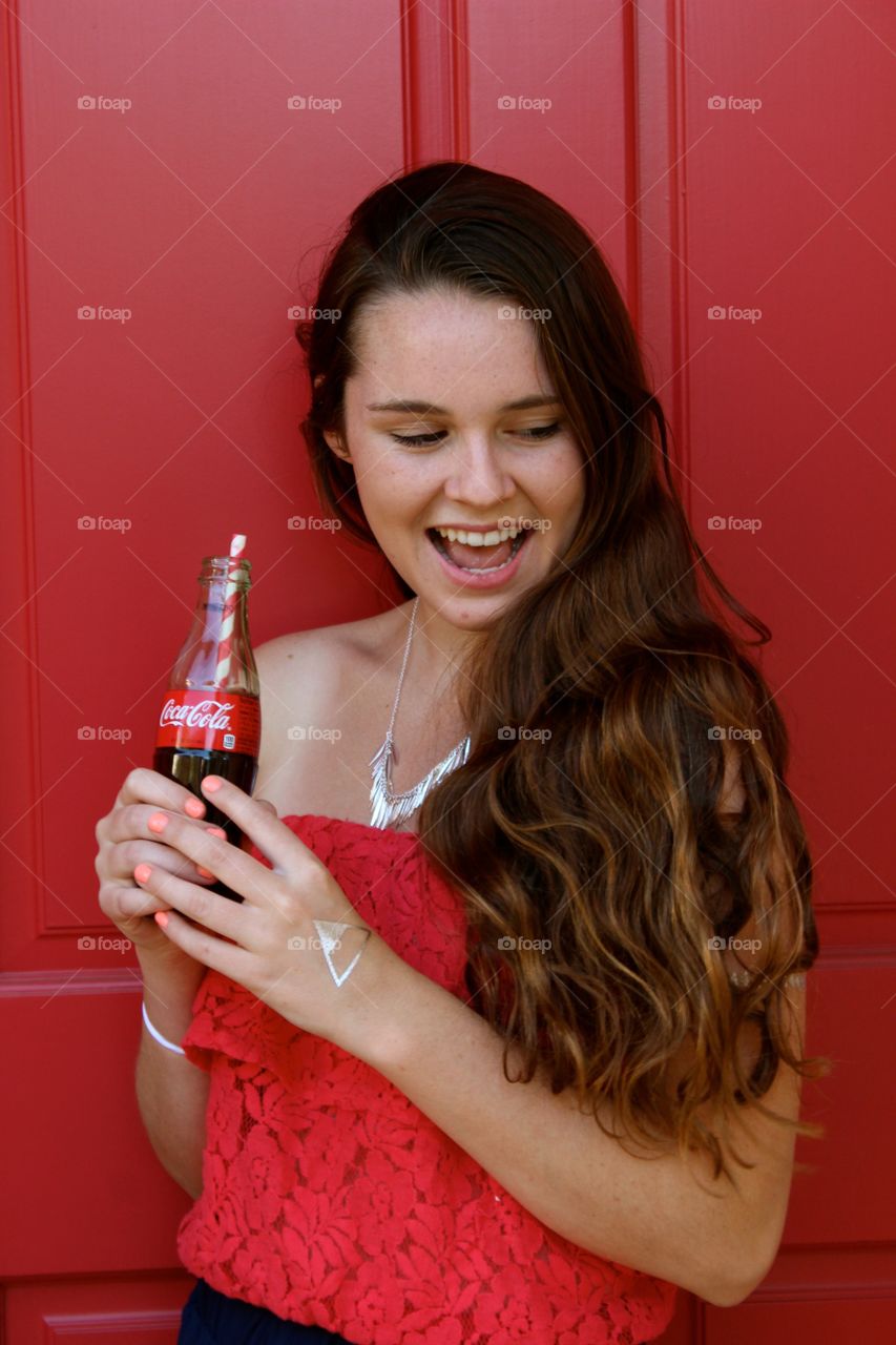 Smiling woman holding soft drink bottle