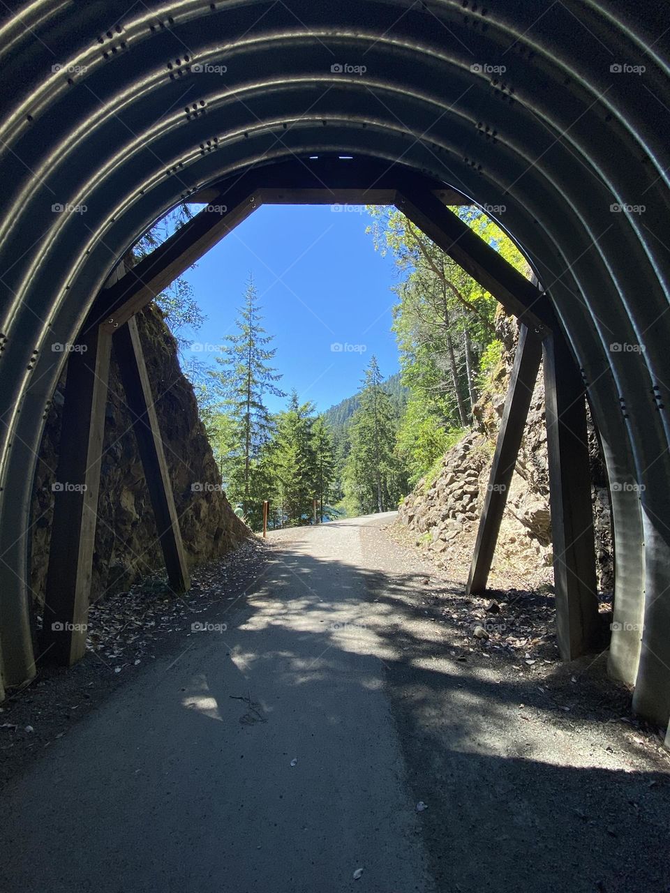 Metal tunnel through a hill for walking path