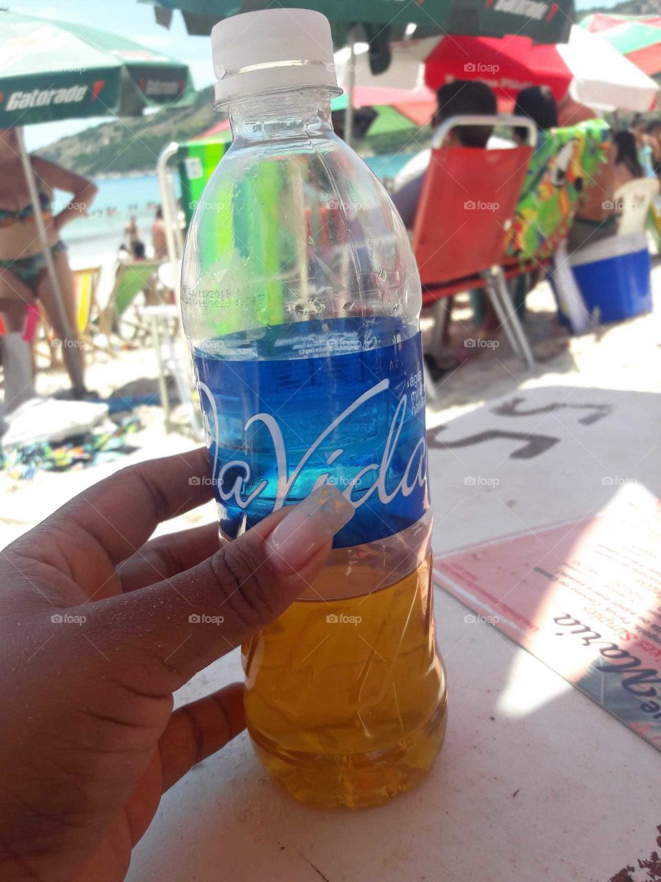 garrafa de água mineral com um chá geladinho, na praia.