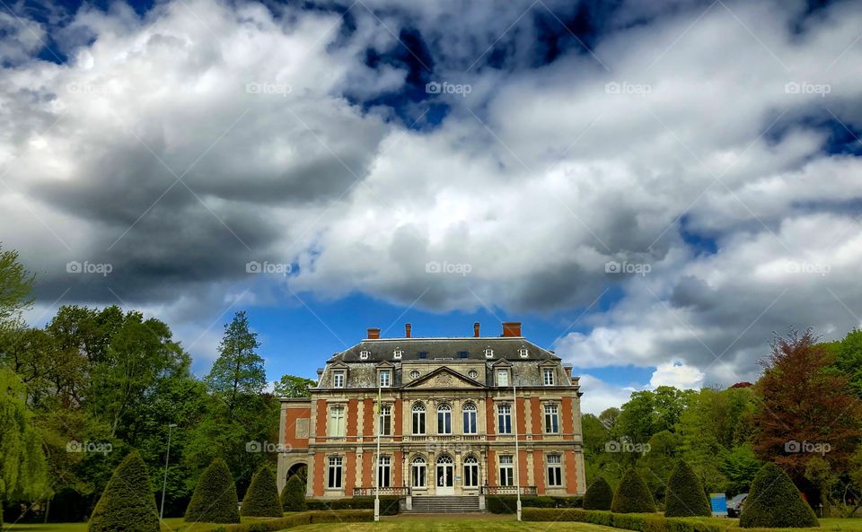 Dark and dramatic clouds over the castle of domain De Horst in neoclassical style in Schoten near Antwerp 