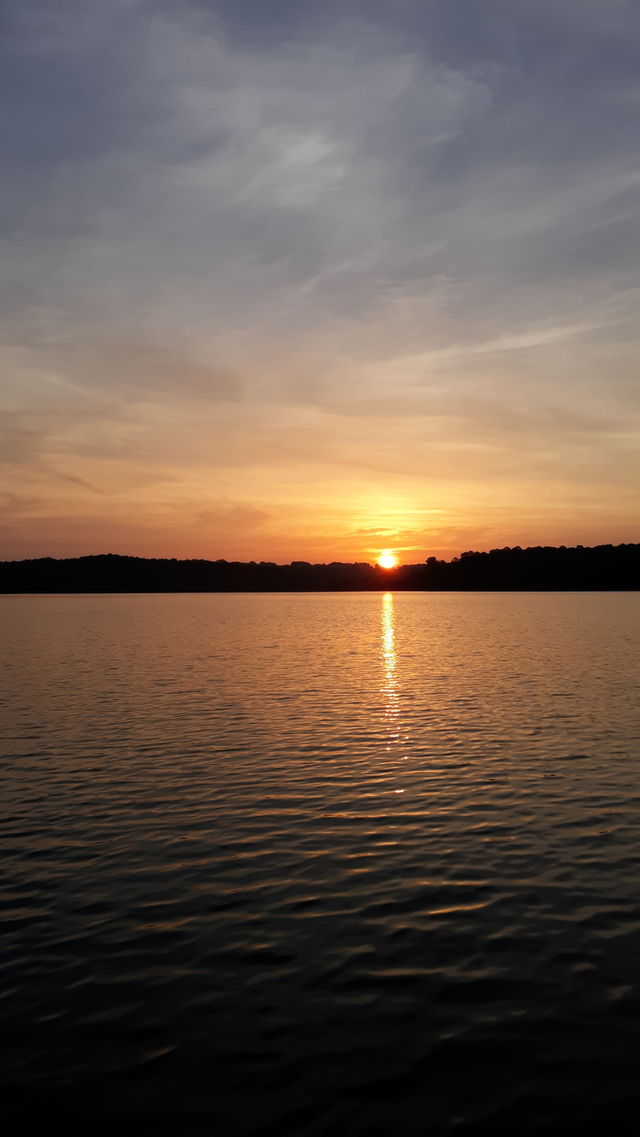 Sun rising over tree line on the lake