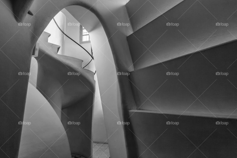 An old corridor in a building with spiral staircase in black and white