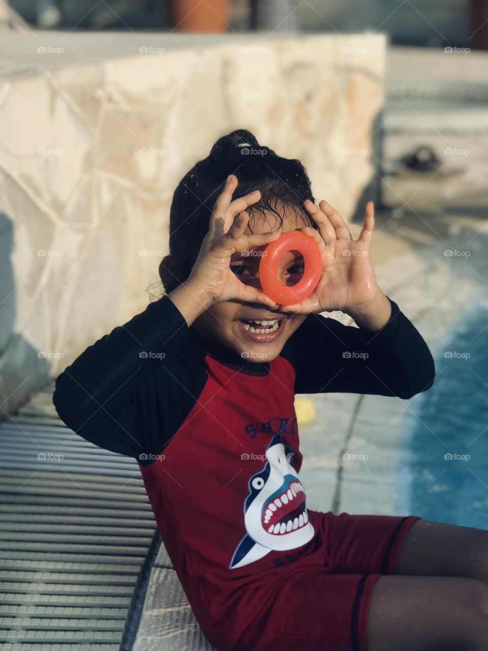 A cute baby playing with circle toy at swimming pool with a beautiful smile 😊 in summertime 