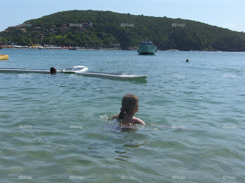 Ella nada en mar brasilero en verano