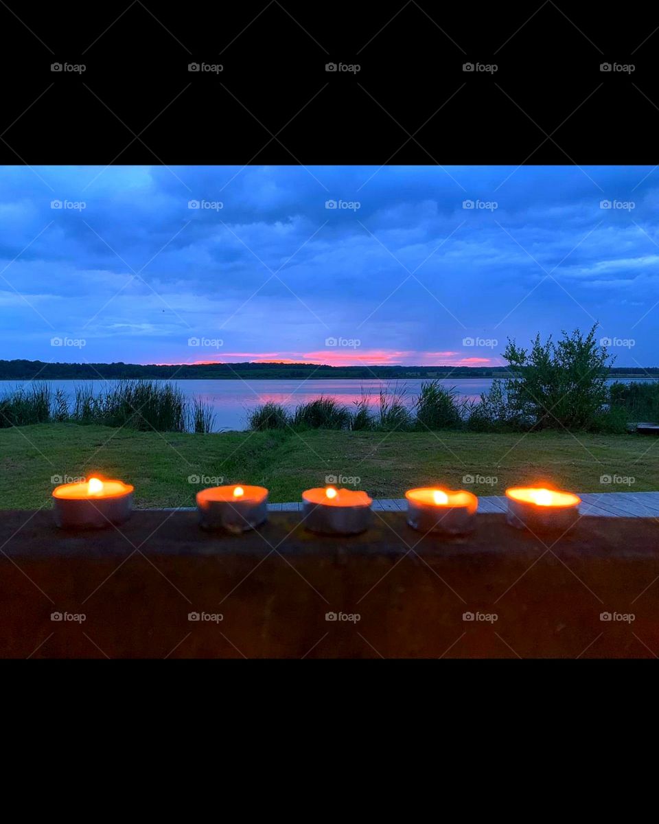 Sunset on the river.  Candles on the terrace and red horizon on the river horizon