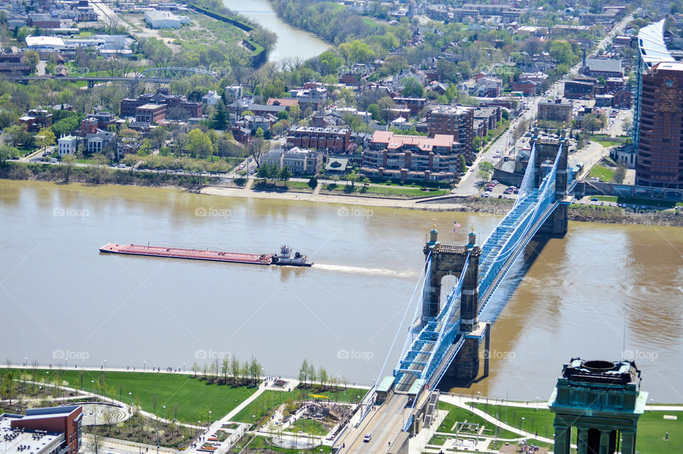 Roebling Bridge over the Ohio River in Cincinnati and Northern Kentucky with a barge in the river