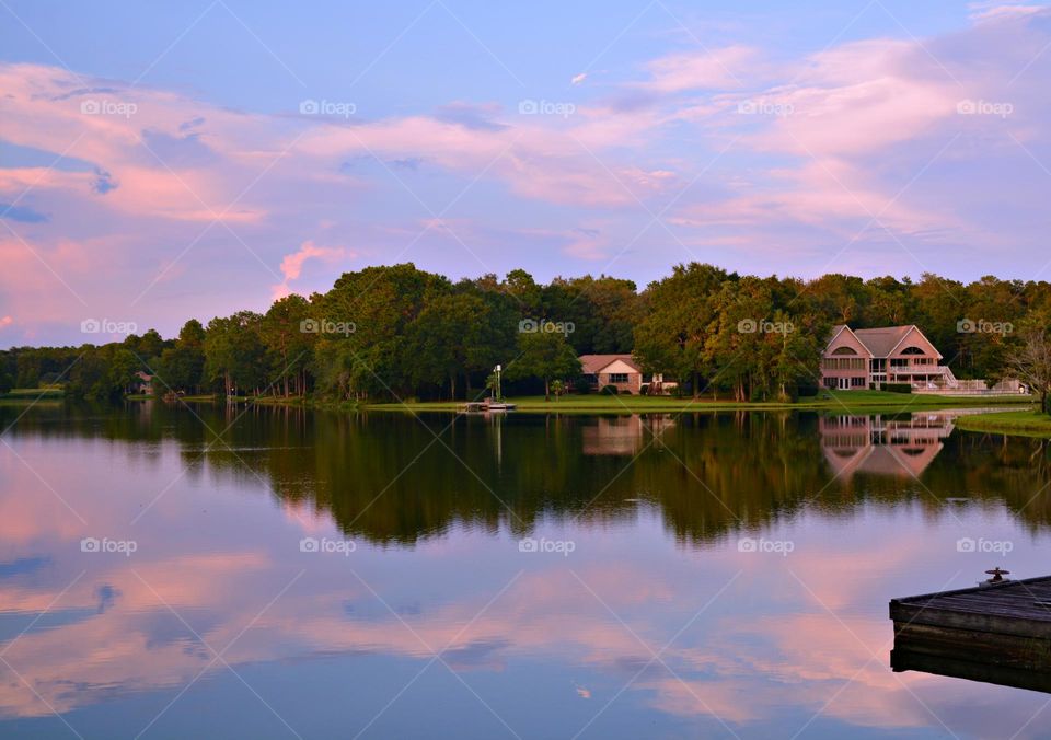 Summer Sunrise - A serene and colorful sunrise over the lake, with the sky's pink and blue hues reflected on the calm water, creating a beautiful mirrored effect