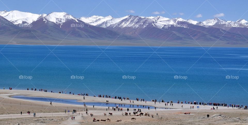 the coast of the namtso lake in Tibet. pilgrims and tourists on the shore