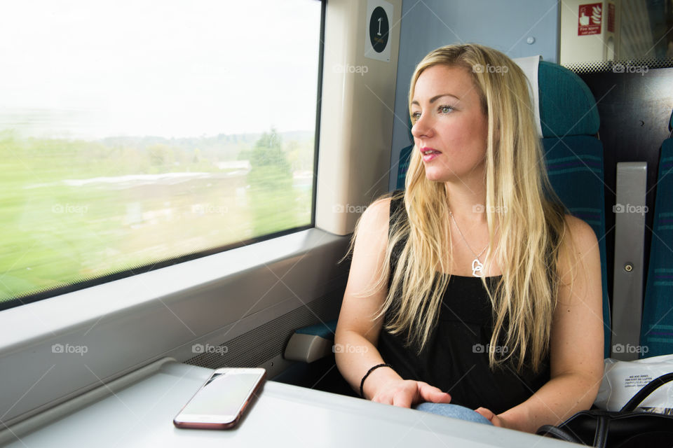 Woman looking out the window on the train from Gatwick Airport to London.