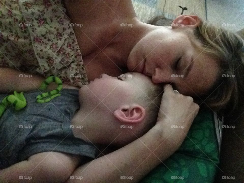 Sweet dreams . Mother caught napping with son 