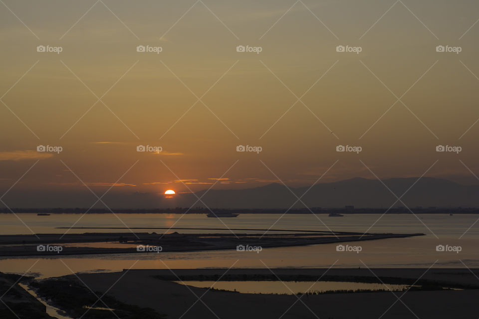 Sun rising at low tide.