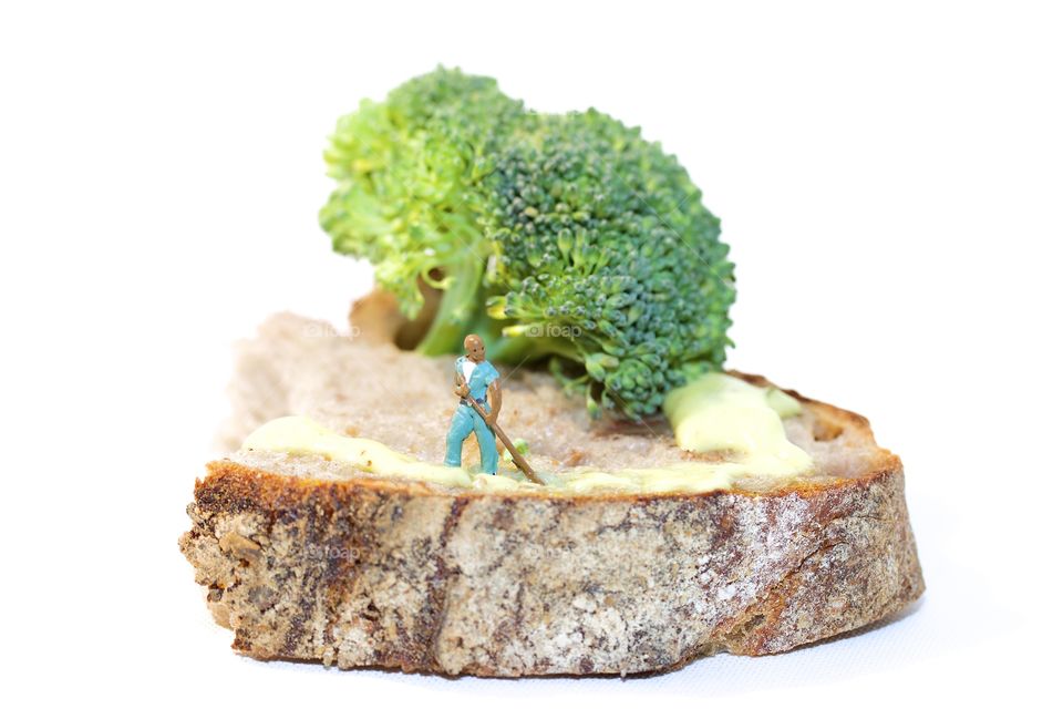 Figurine and broccoli on bread