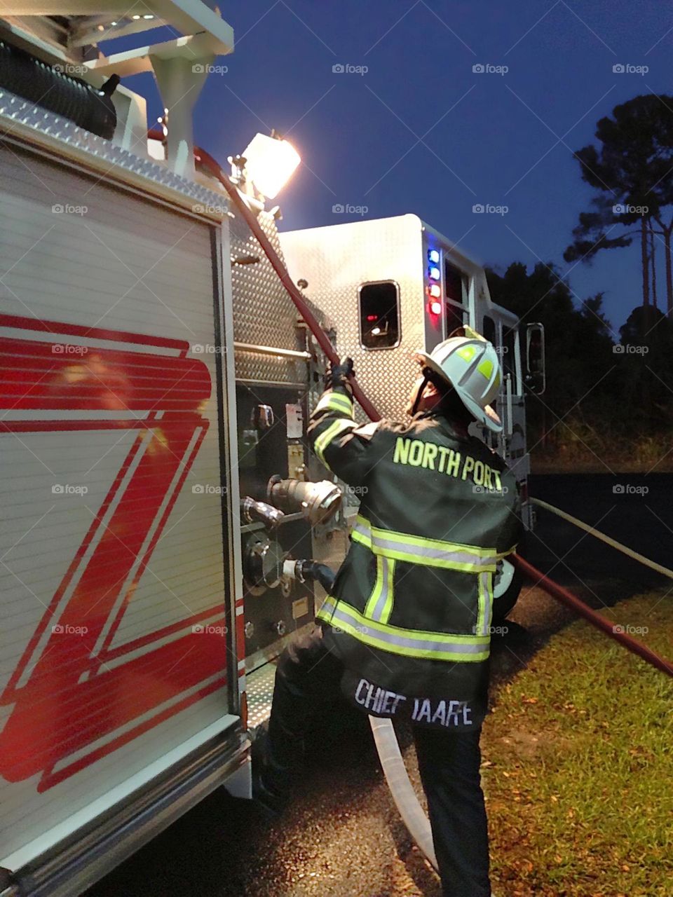 Fireman lights up the night while hard at work.
