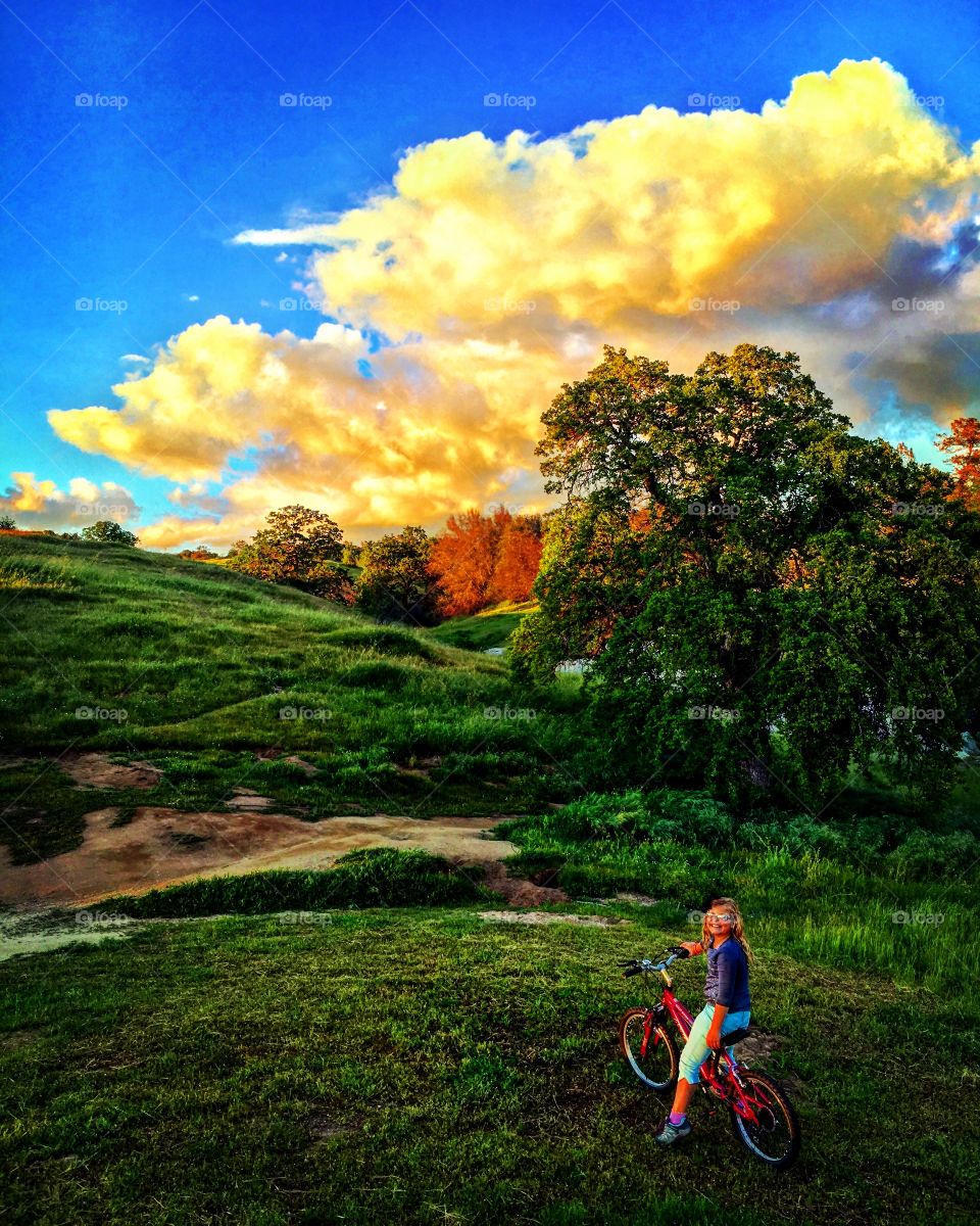 Foothills child bicycle clouds sunset green wild oaks color vibrant 