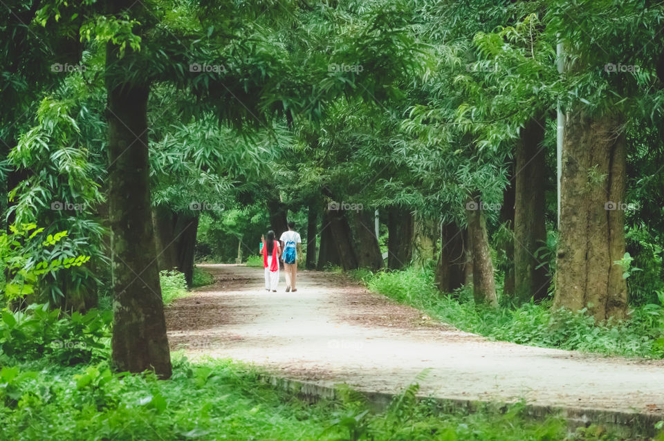 Portrait of two joyful young loving Couple walking in a green autumn park on a romantic summer day. Pre-wedding marriage engagement concept. Togetherness composition. Botanical garden, Kolkata, India