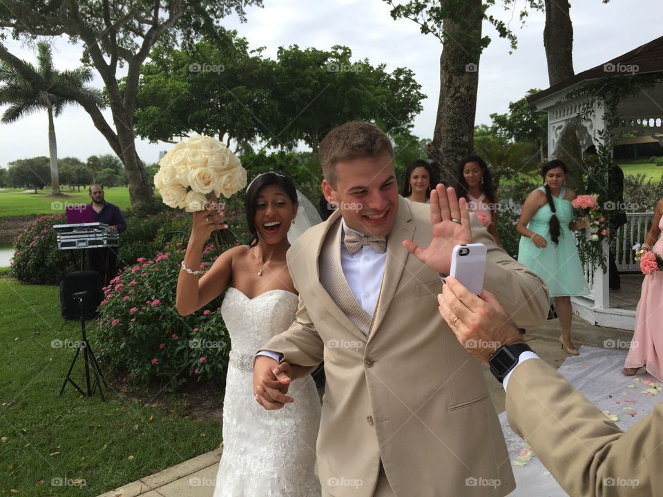 Wedding . Happy bride and groom after wedding ceremony video chatting with mobile phone