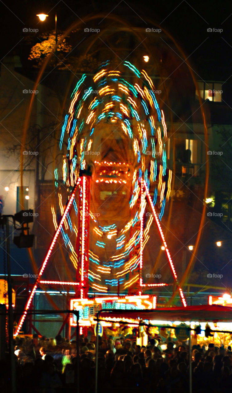 SLOW MOTION BLUR OF A FAIRGROUND WHEEL AT NIGHT.
