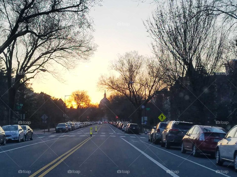 A view of the US Capitol dome from a distance while walking down East Capitol Street during sunset. Photo taken March 2018.