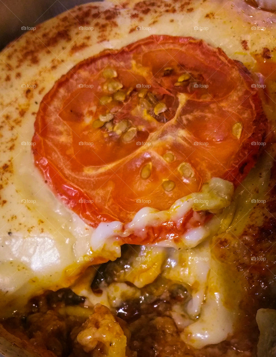 Moussaka with a tomato slice, close-up