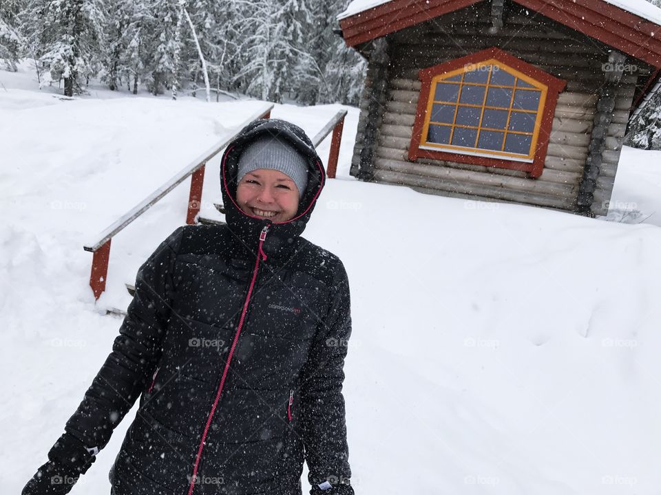 Enjoying the ski trip. Sauna cabin in the background.