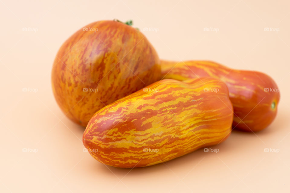 Striped tomatoes on peach background