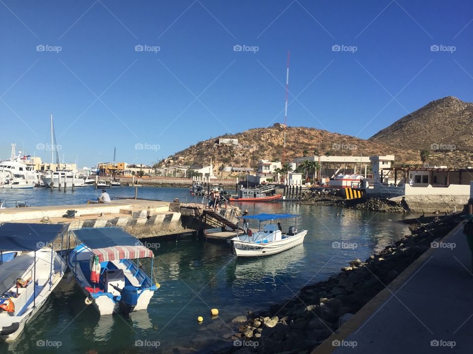 Bright, clear, sunny day on the boat dock in Cabo San Lucas in the Mexican Riviera with hills in he background