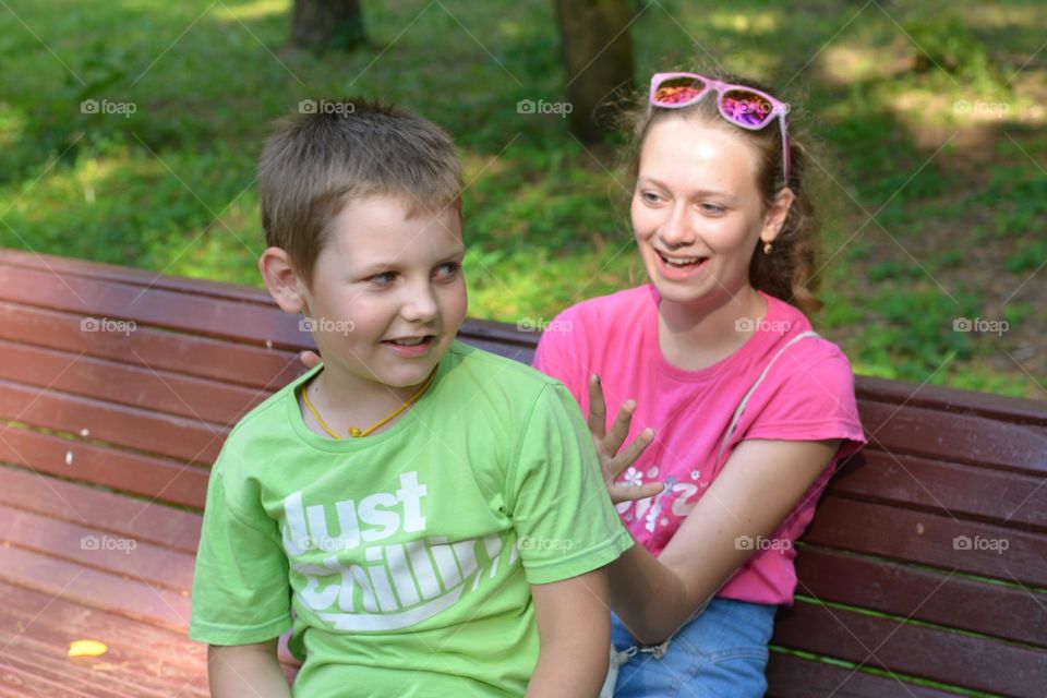 children on a bench in the summer city park