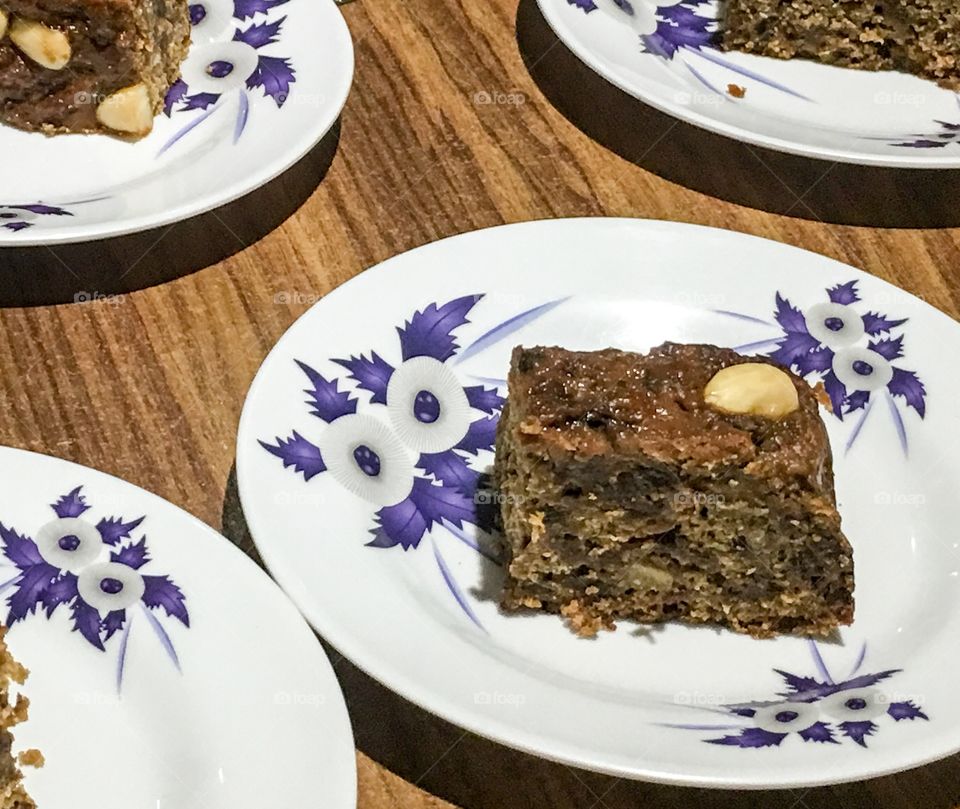 Slice fruit cake on blue white floral plate