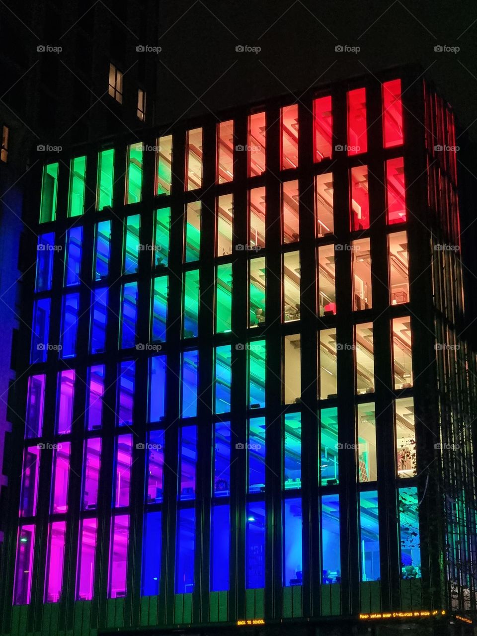 Colorful glass facade of highrise building with regular rectangular pattern