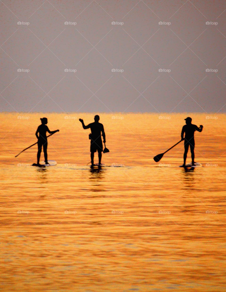 Standup paddleboarding early in the morning in Larnaca, Cyprus . The water turned gold from the rising sun, and the moment captured was just beautiful