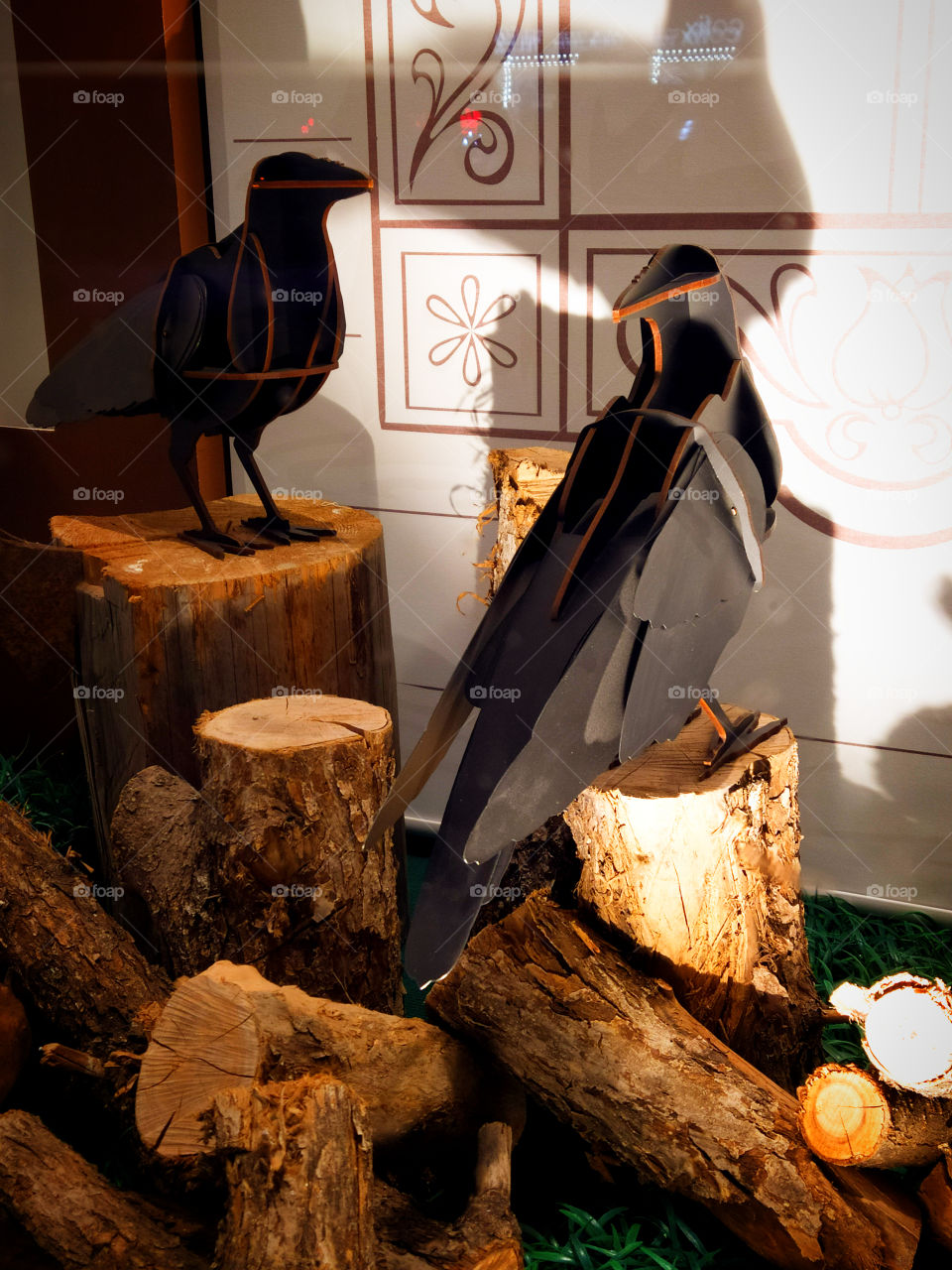 Two black wooden crows on a tree log