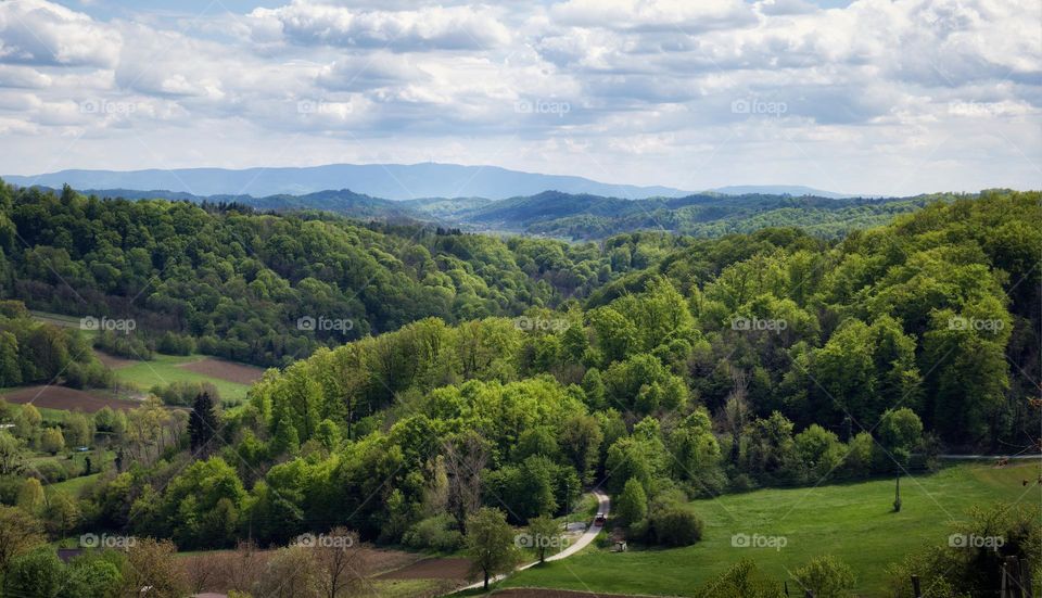 Beautiful landscape scenery with forest on green hillside and mountain Sljeme in the background at Klenice, Croatia, county hrvatsko zagorje