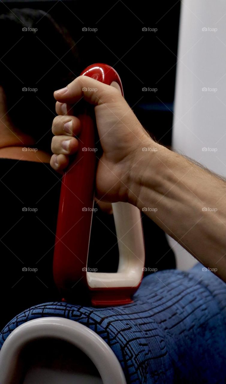 Man hand holds the seat handle in the light rail