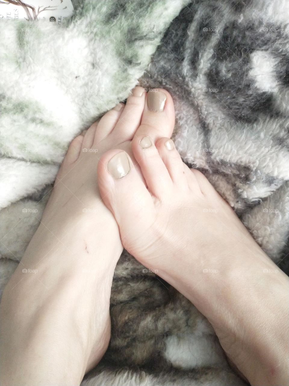 Nude feet in fluffy blanket