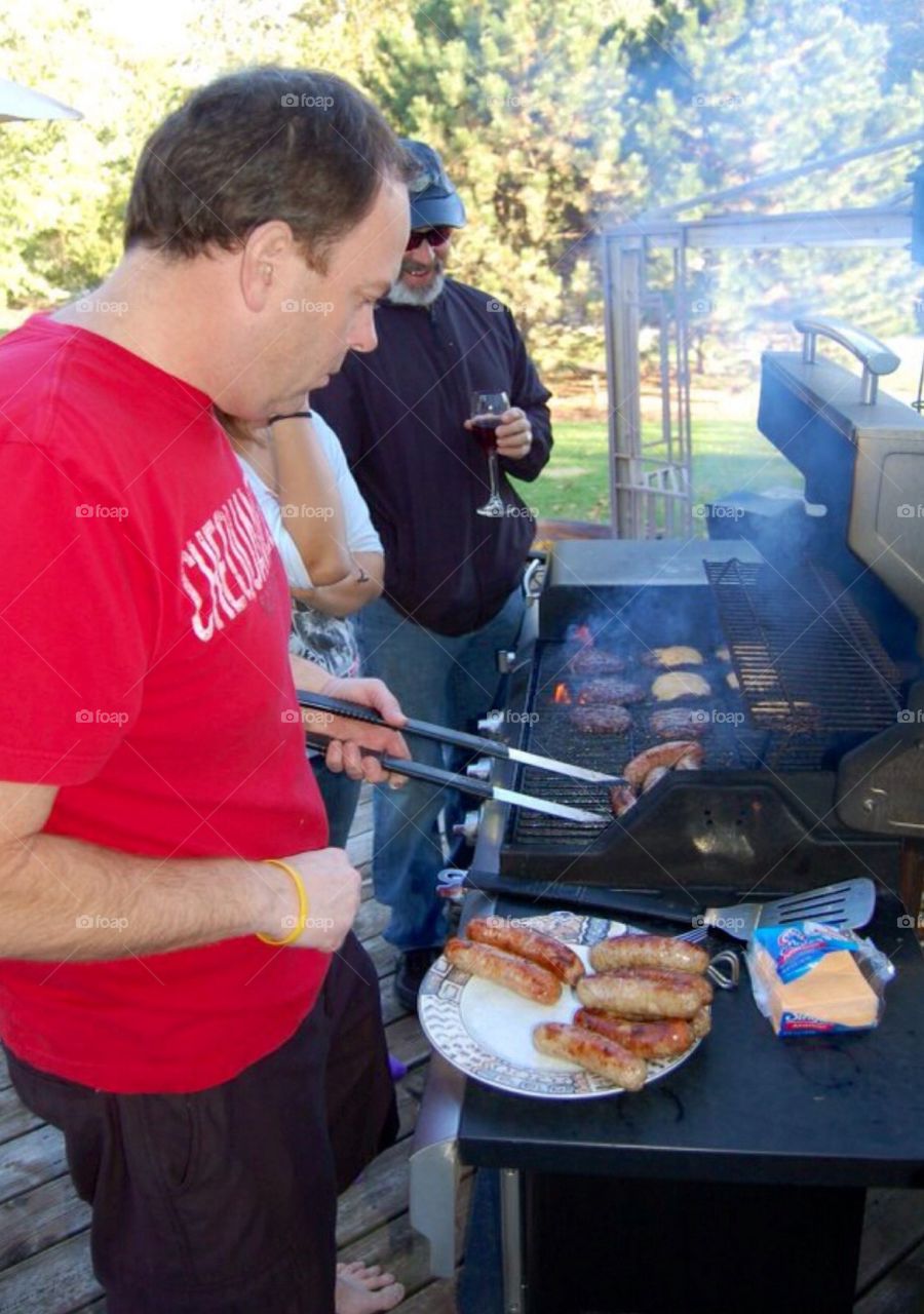 Outdoors grilling. Men grilling at family get together.