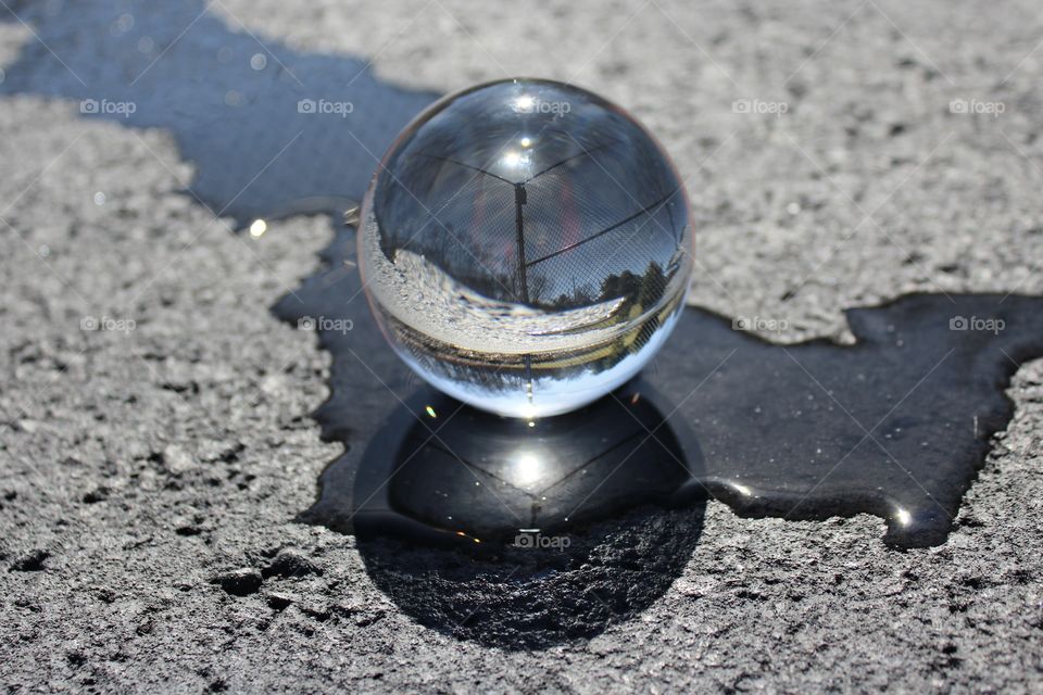 Skatepark Reflections; Crystal ball in water on a sunny day that created a mirror effect on the asphalt.
