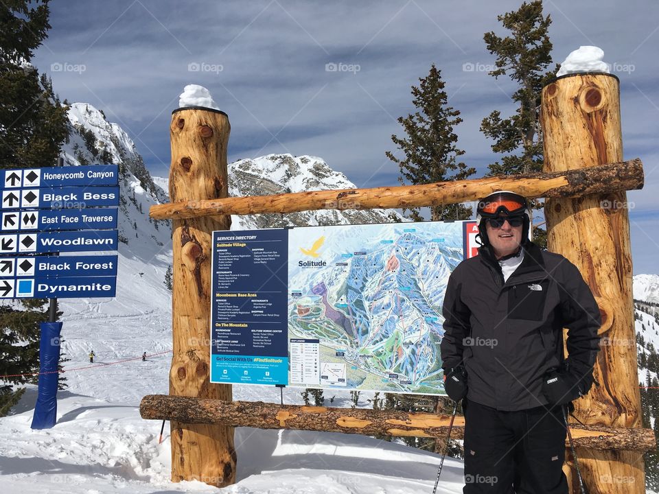 Man in front of ski mountain sign 